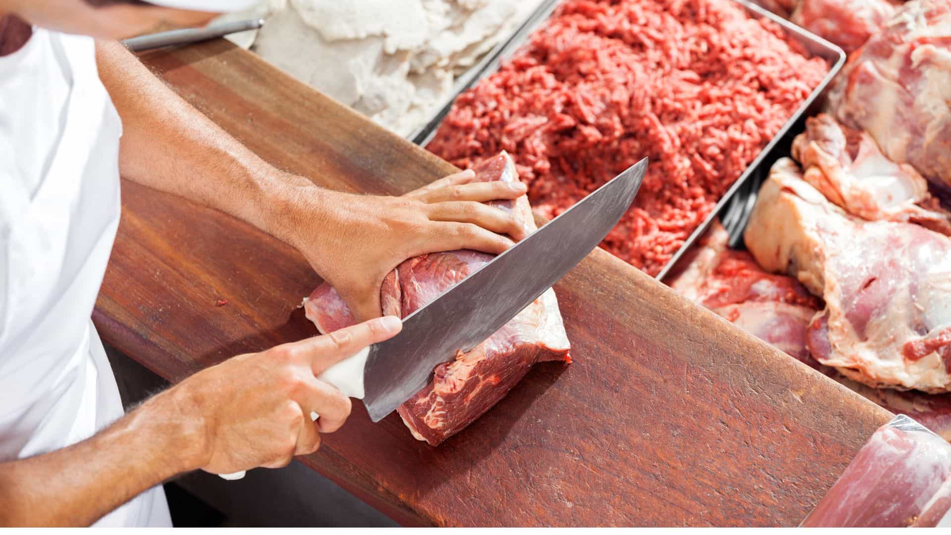 Butcher cutting a piece of meat.