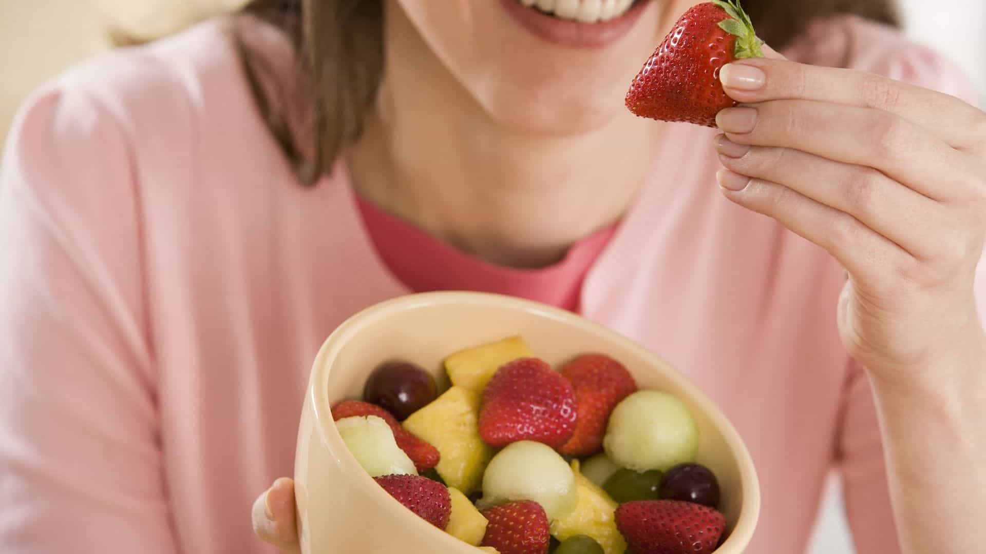 Woman eating fruit salad.