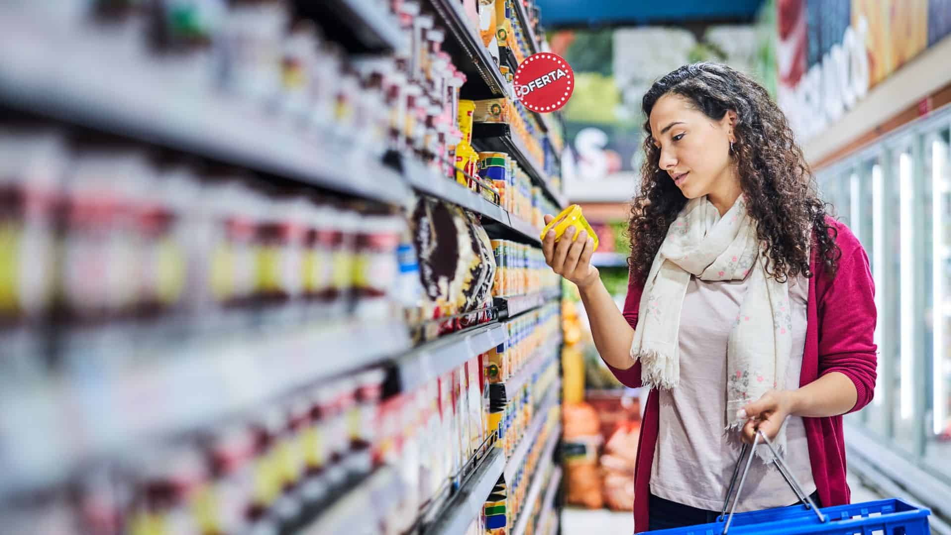 Woman picking up item in a grocery store.