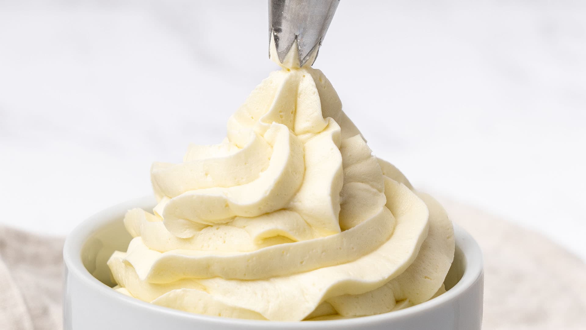 Piping American butter cream into a cup.