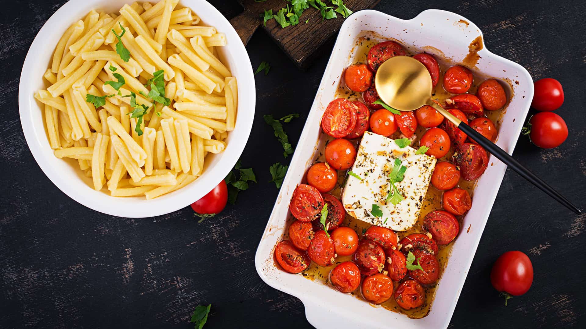 feta and tomatos in a baking dish with a side of spaghetti