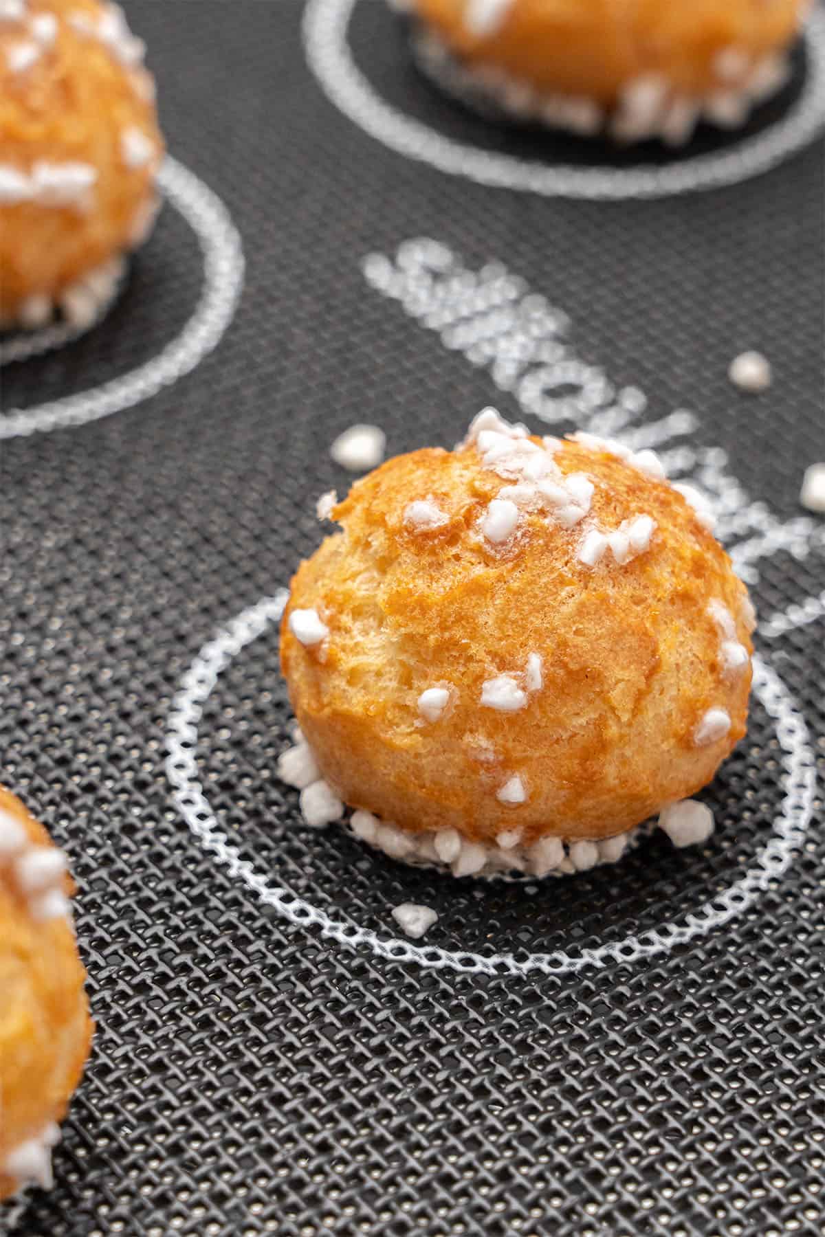 Chouquettes on a baking mat.