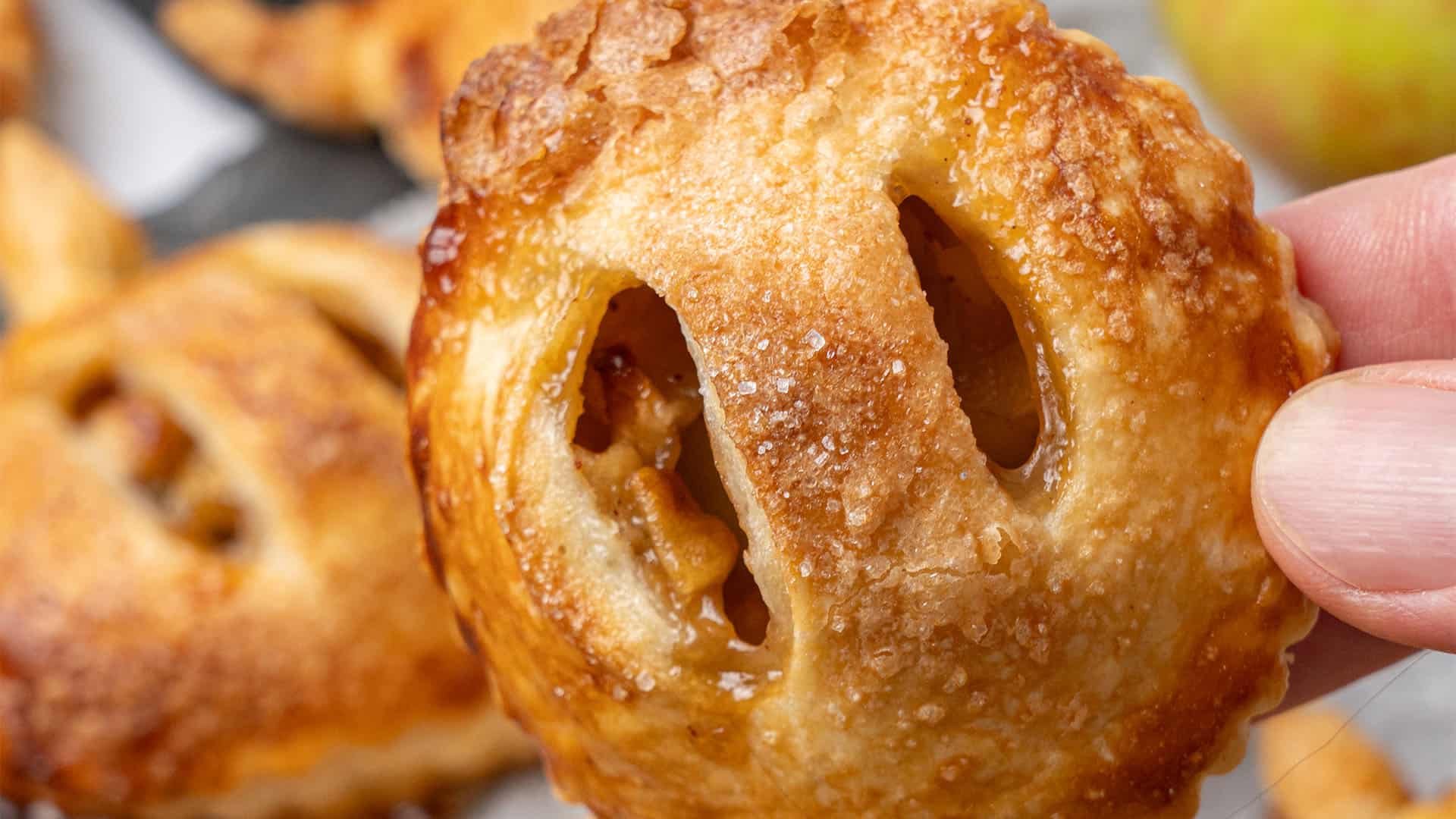 a hand is holding Apple Hand Pie.