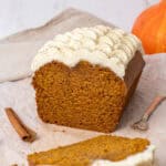 pumpkin bread with cream cheese frosting on a baking paper.