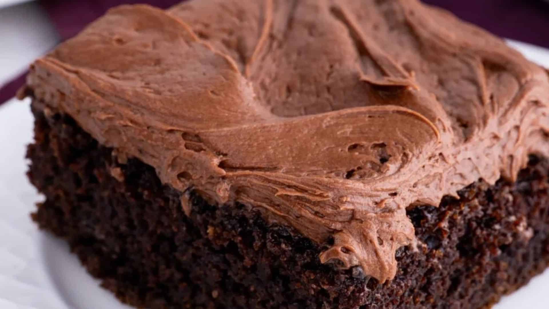 A slice of chocolate sheet cake with cream cheese topping.