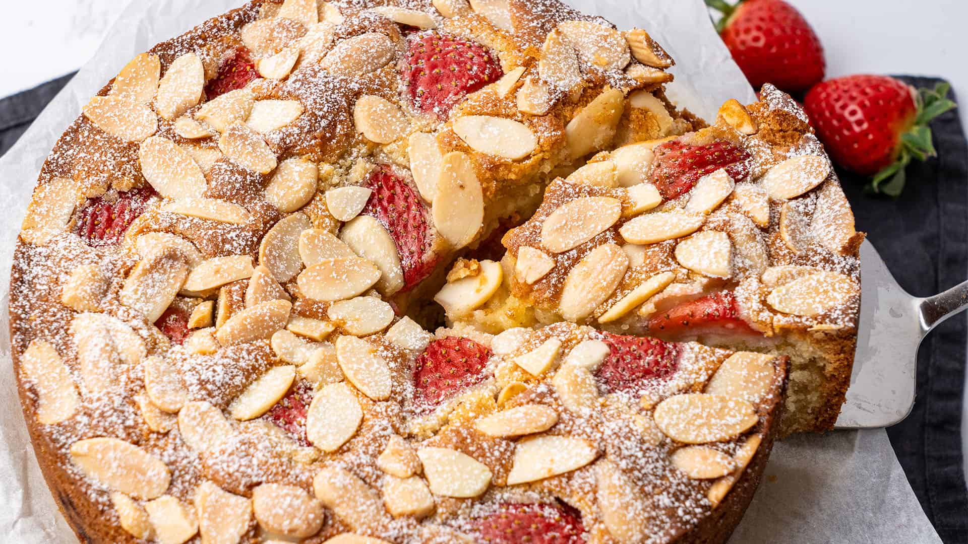 Almond strawberry cake on a baking paper.