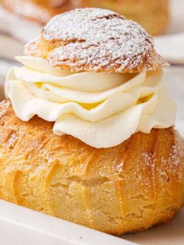 A few cream puffs on a cake stand.