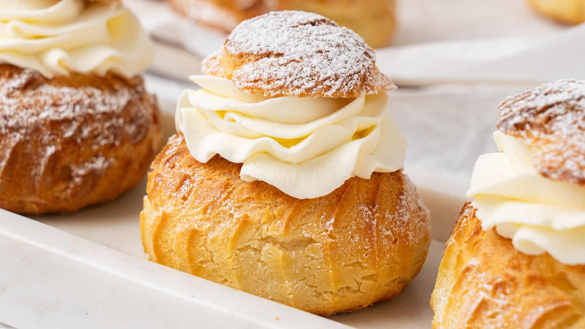 A few cream puffs on a cake stand.