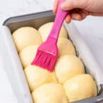 Applying egg wash on a brioche bread.