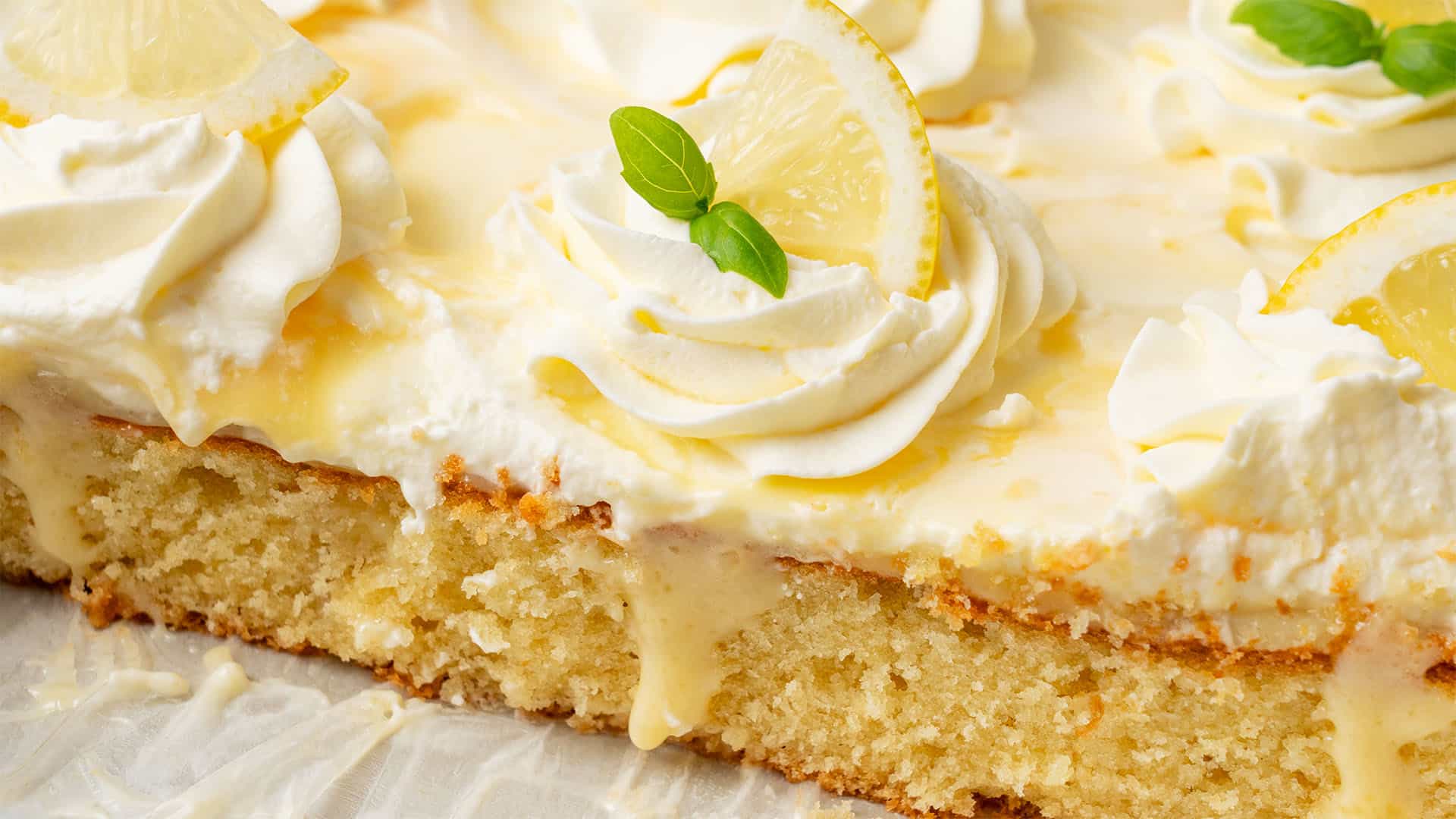 A slice of lemon poke cake on a plate.