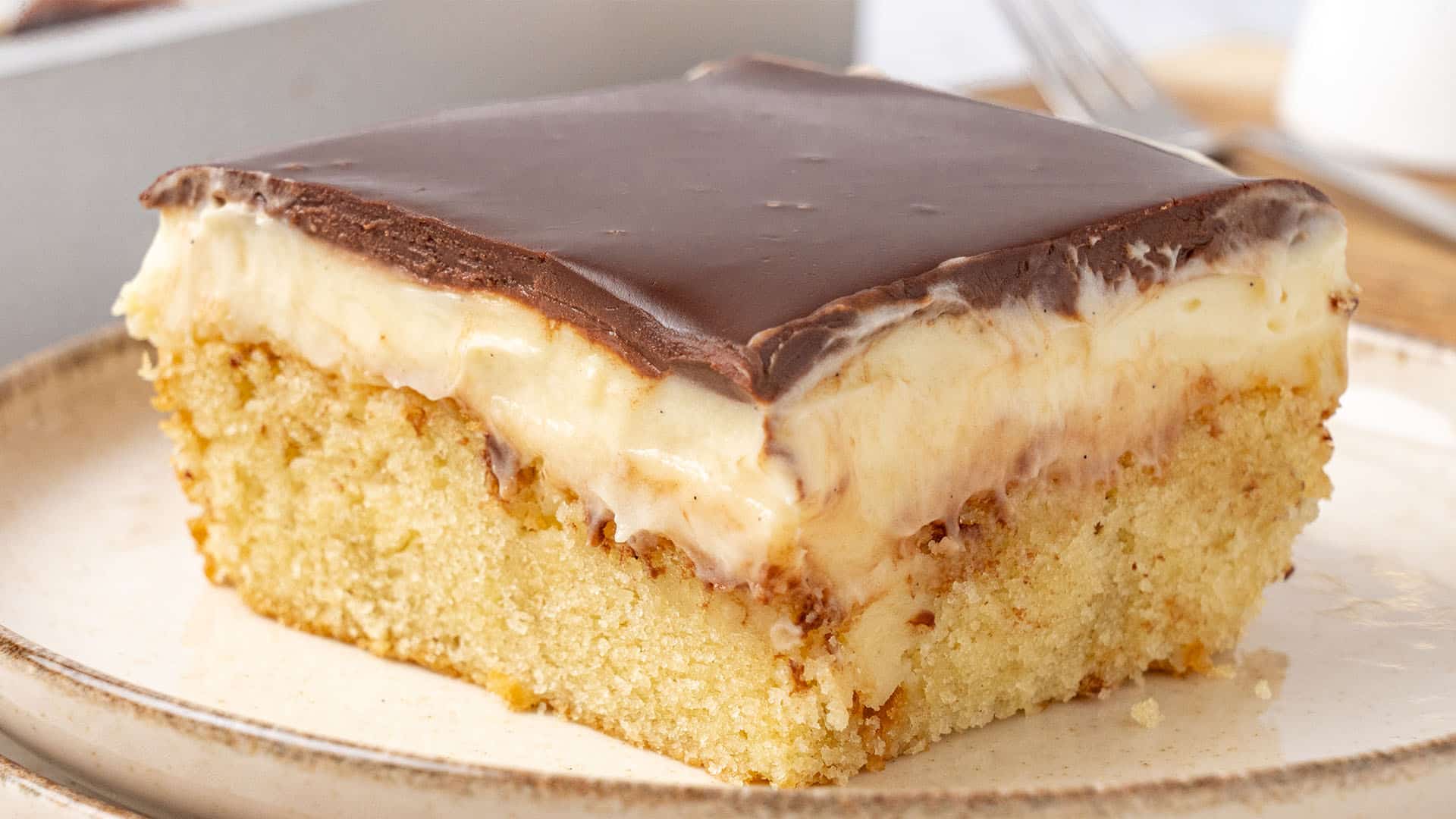 A slice of Boston cream poke cake.