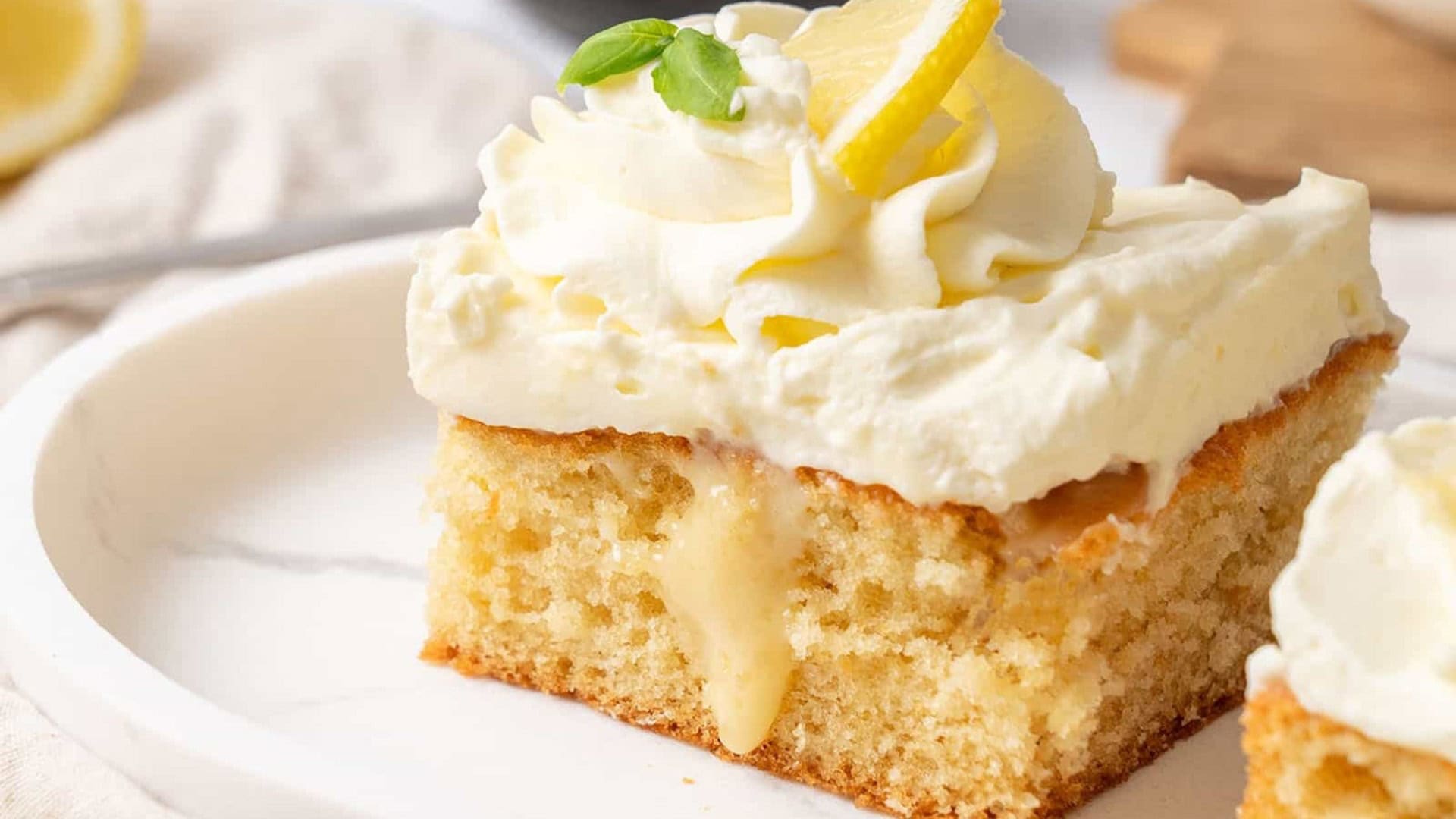 lemon poke cake with lemon frosting and lemon slice