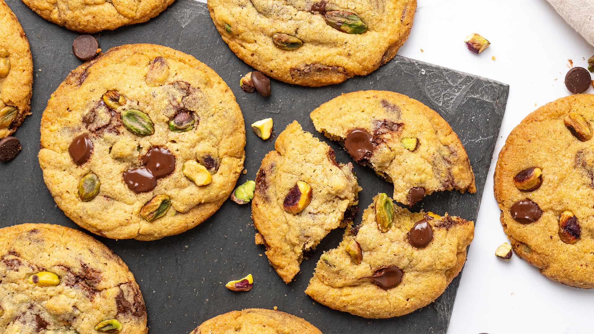 Pistachio cookies on a cutting board.