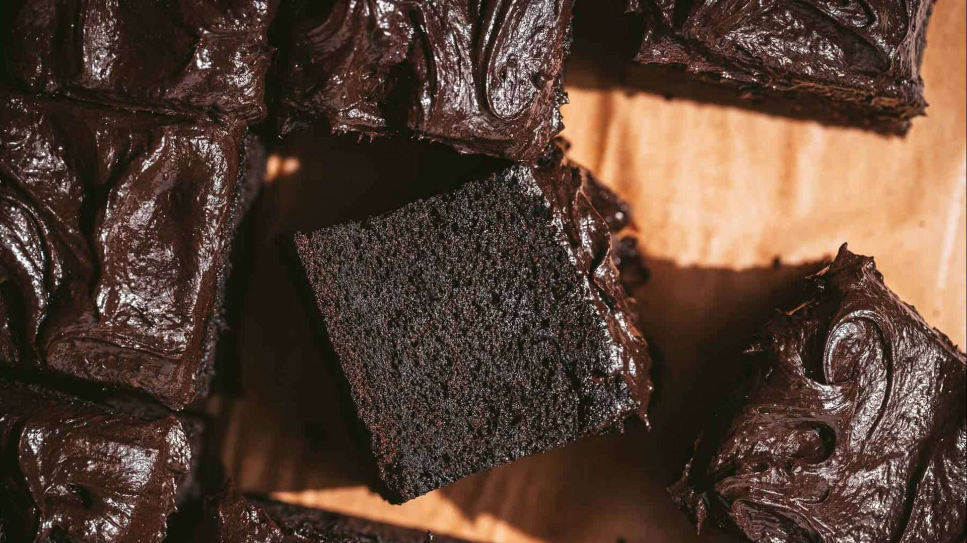 Squares of dark chocolate cake on a cutting board