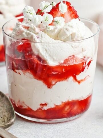 layered strawberry and cream dessert with flower garnish