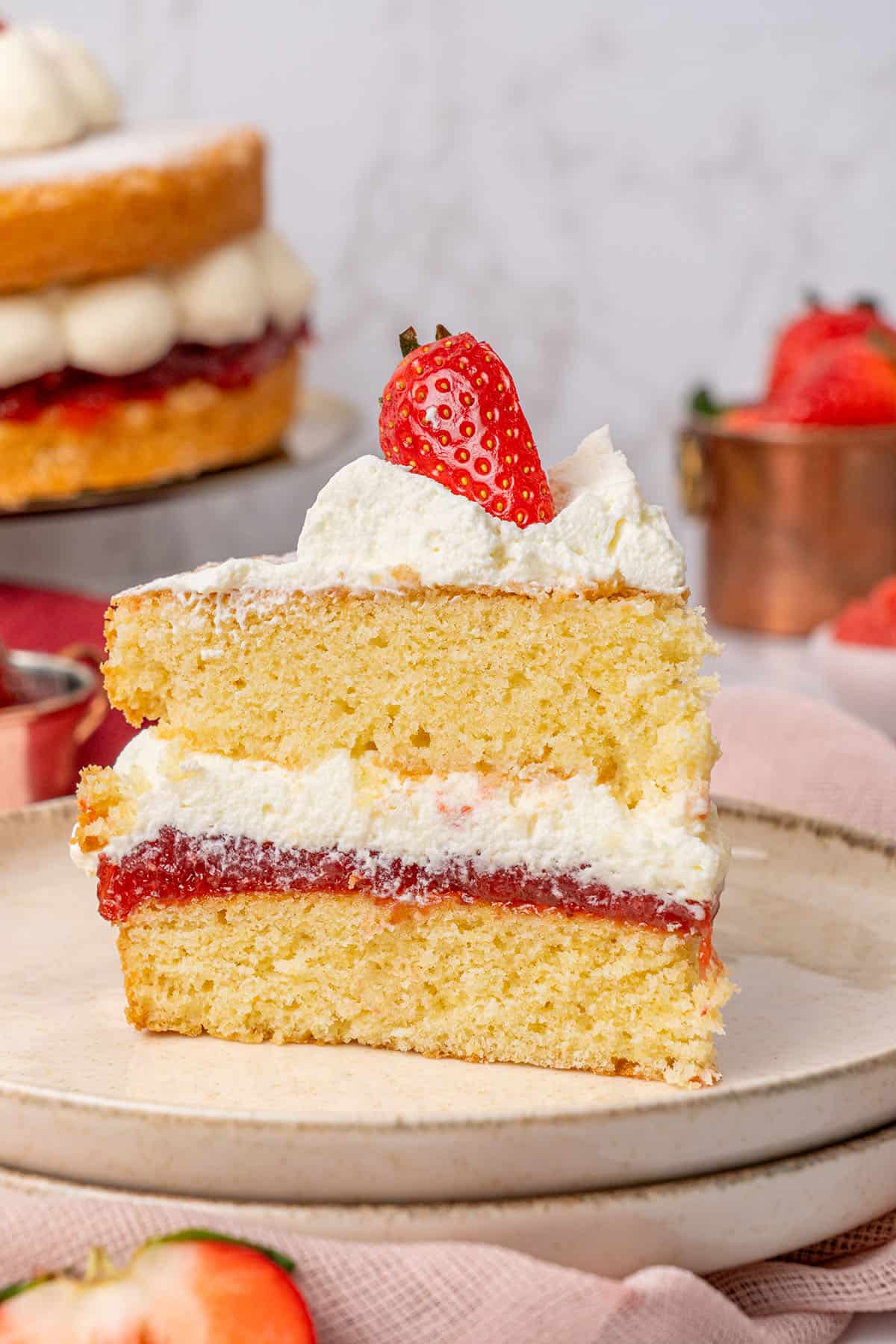a slice of Victoria Sponge Cake on a plate.