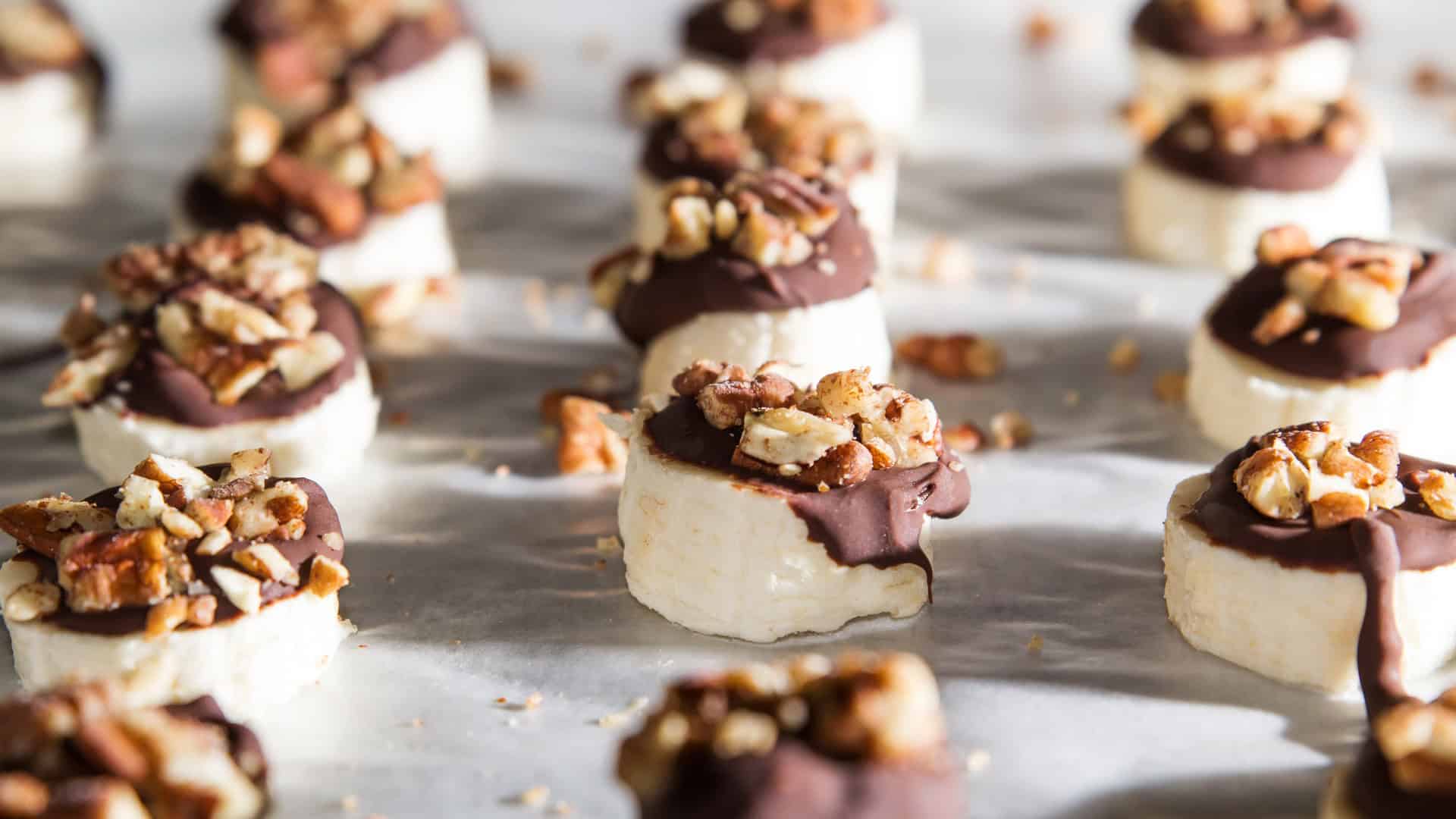 Frozen banana slices with chocolate and chopped nuts