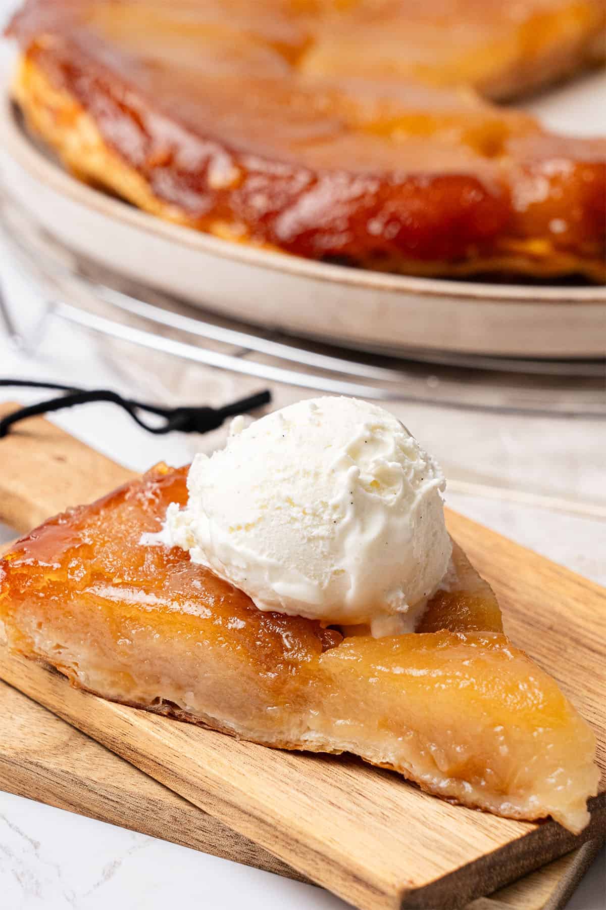 a slice of Apple Tarte Tatin on a plate with ice cream.