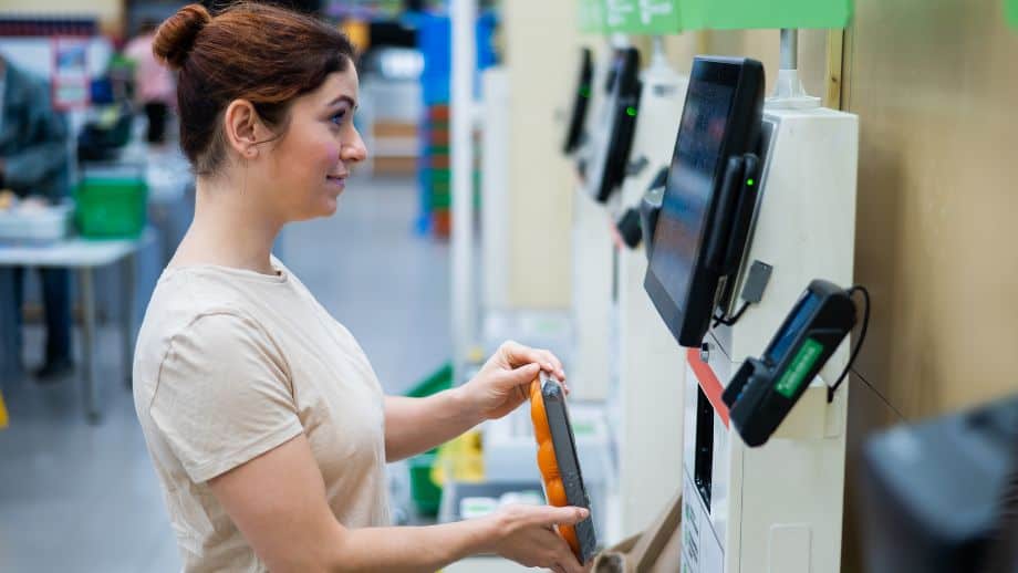 Woman using self-checkout service at supermarket