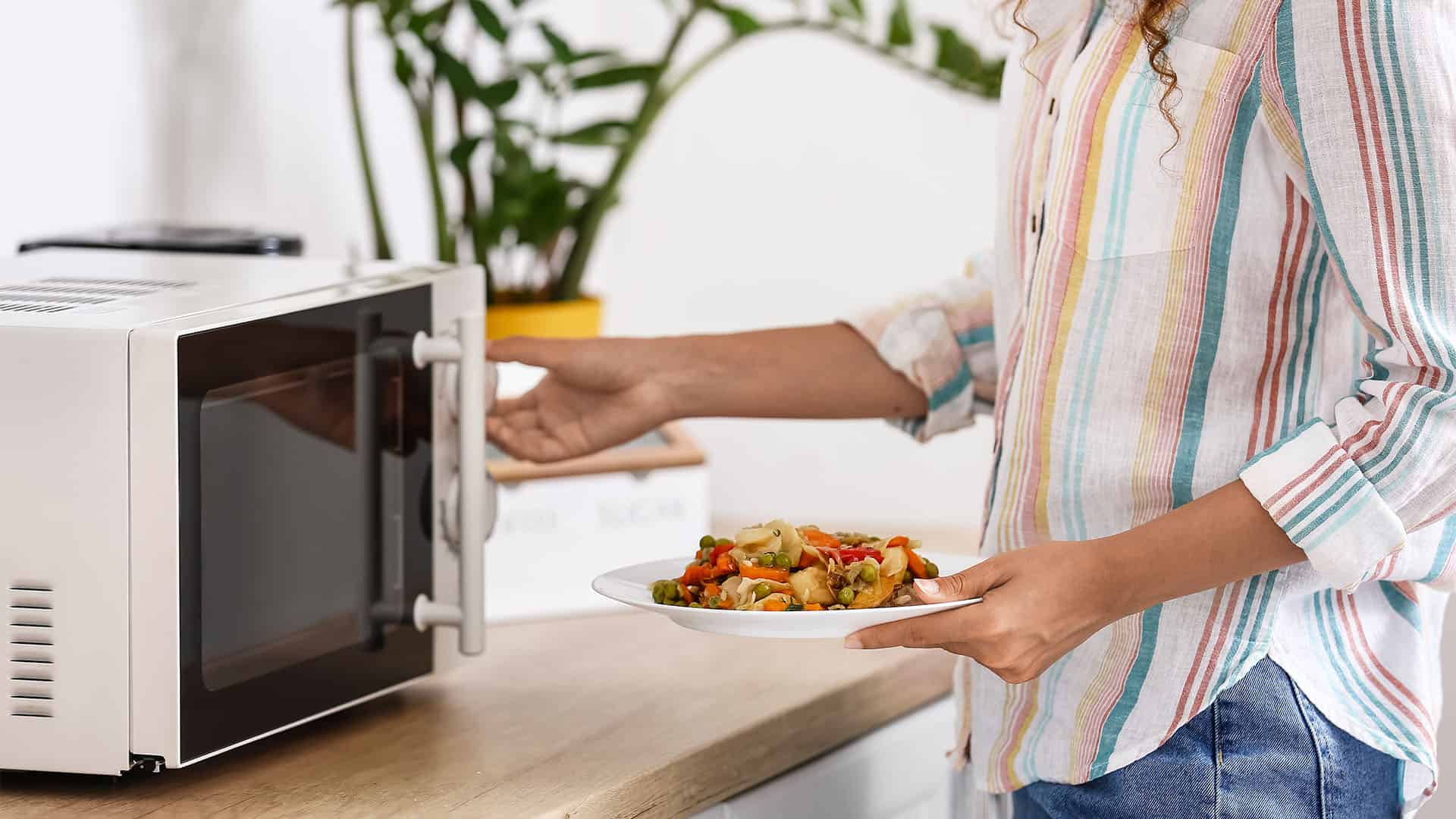 woman put food into microwave.