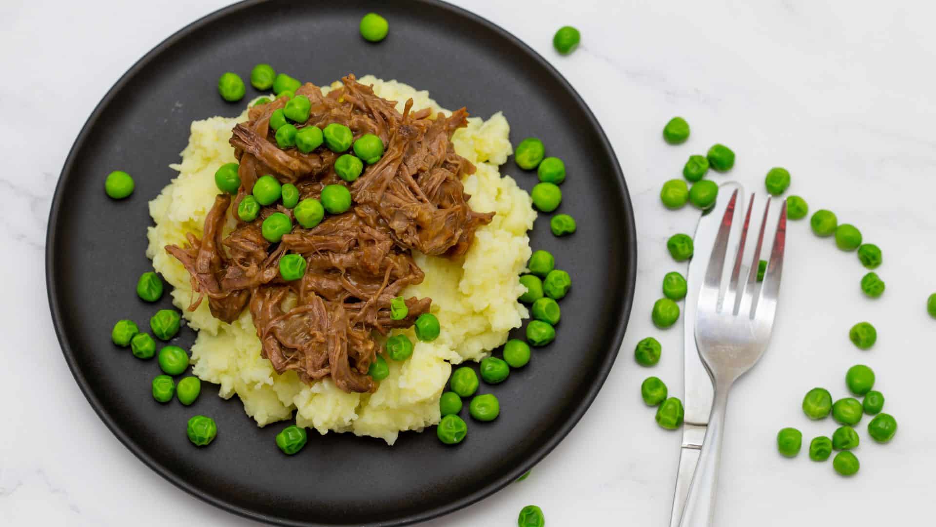 Butterflied beef with mashed potatoe and peas