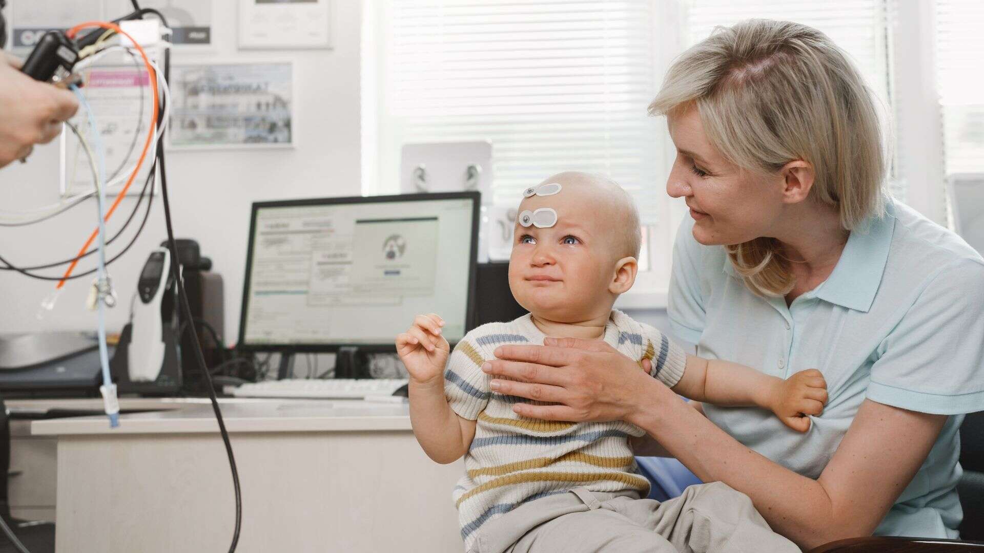 Mother with infant child consulting doctor otolaryngologist