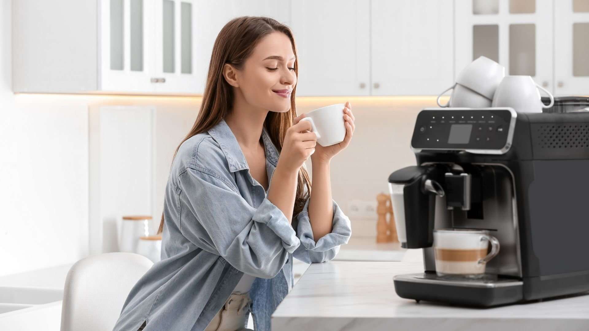 Young woman enjoying fresh aromatic coffee near machine in kitchen