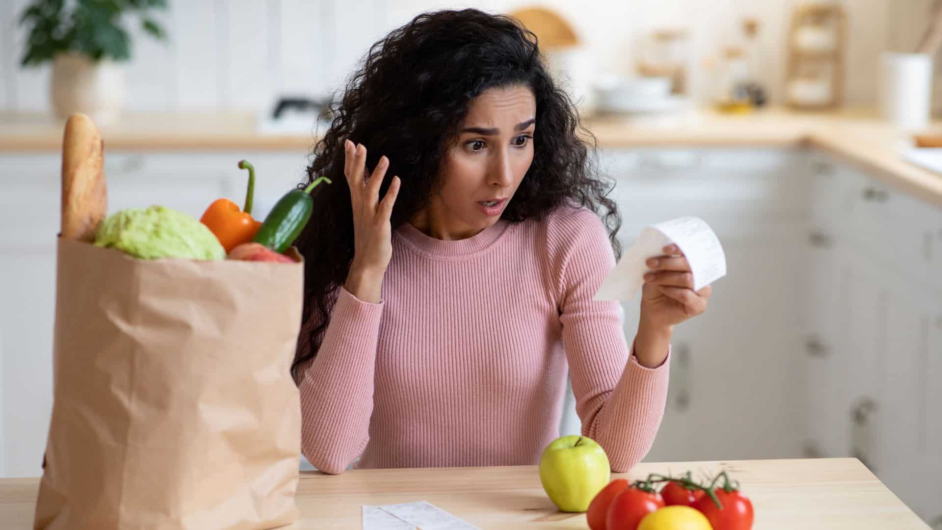 woman shocked by looking at her grocery bill
