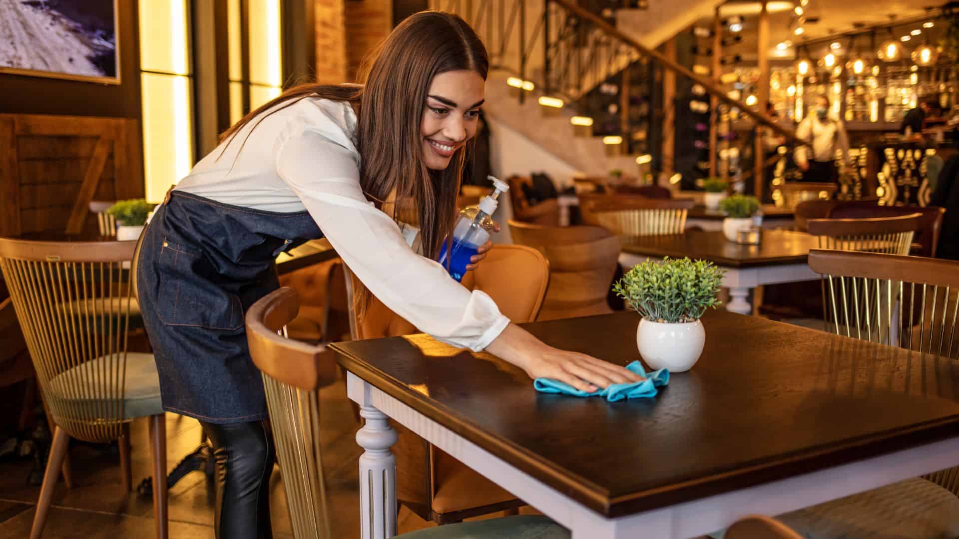 Waitress cleaning up at a restaurant.