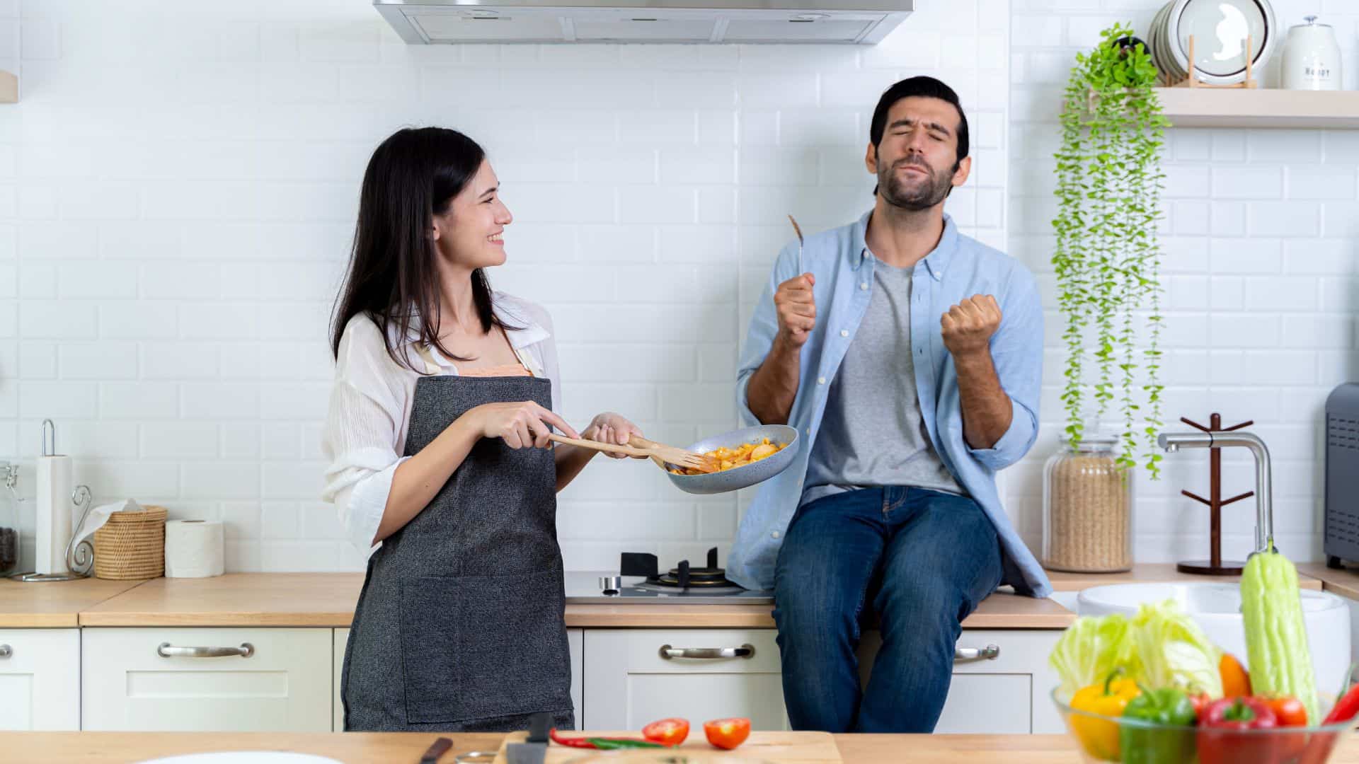 husband sitting on shelf in the ktichen while wife is staring at him