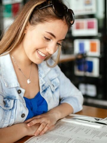 woman glancing through menu deciding on what to order