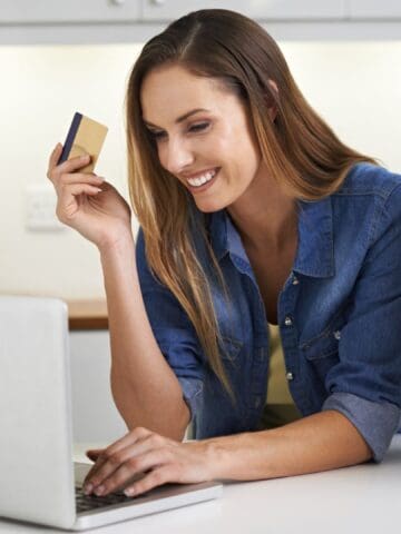 woman holding a card and doing online shopping