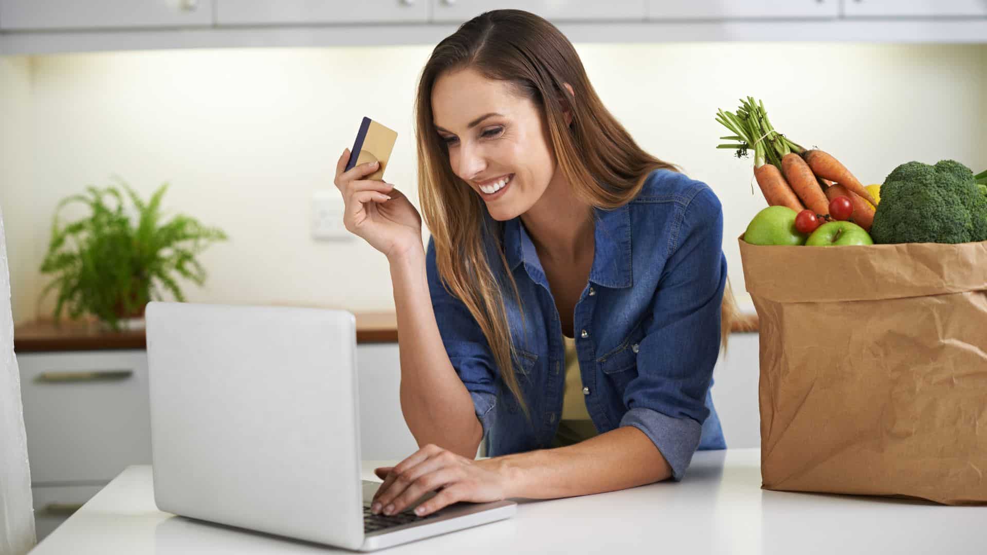 woman holding a card and doing online shopping