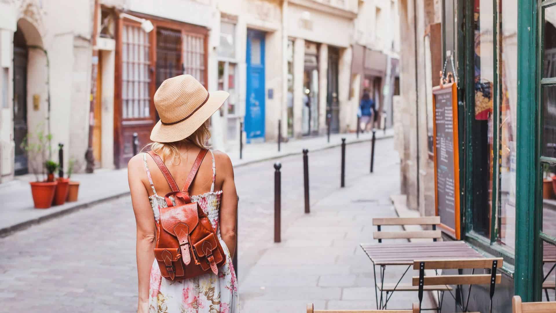 woman tourist walking on the street, summer fashion style, travel to Europe