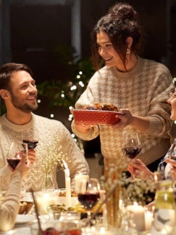 happy smiling friends having dinner at home in evening