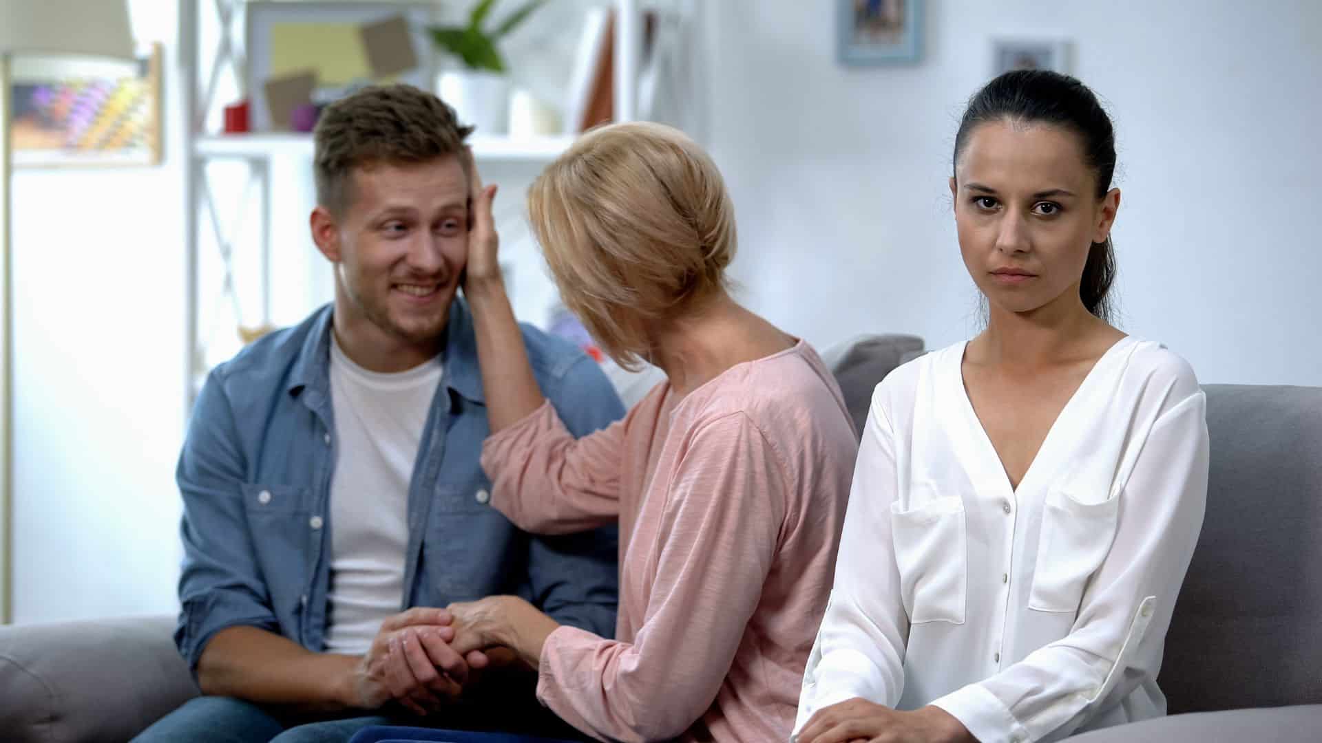 man talking with mother at home, not paying attention on woman