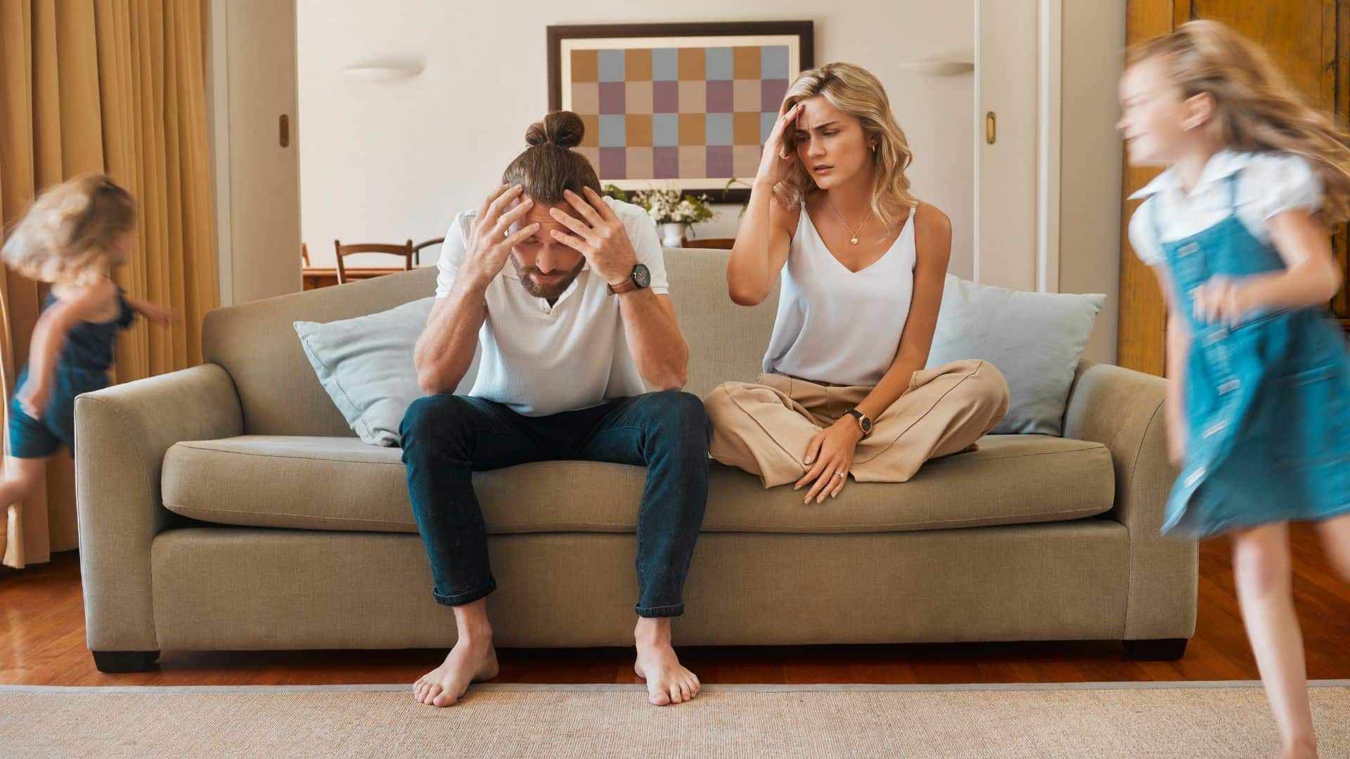 parents sitting with headache while kids running arund