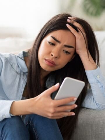 sad woman looking at phone