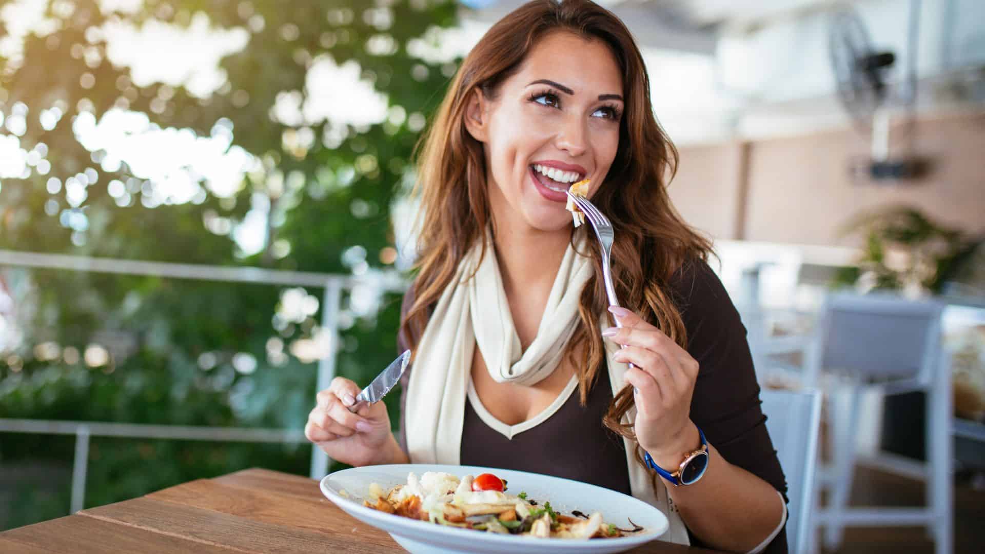 woman eating salad at a restaurnat