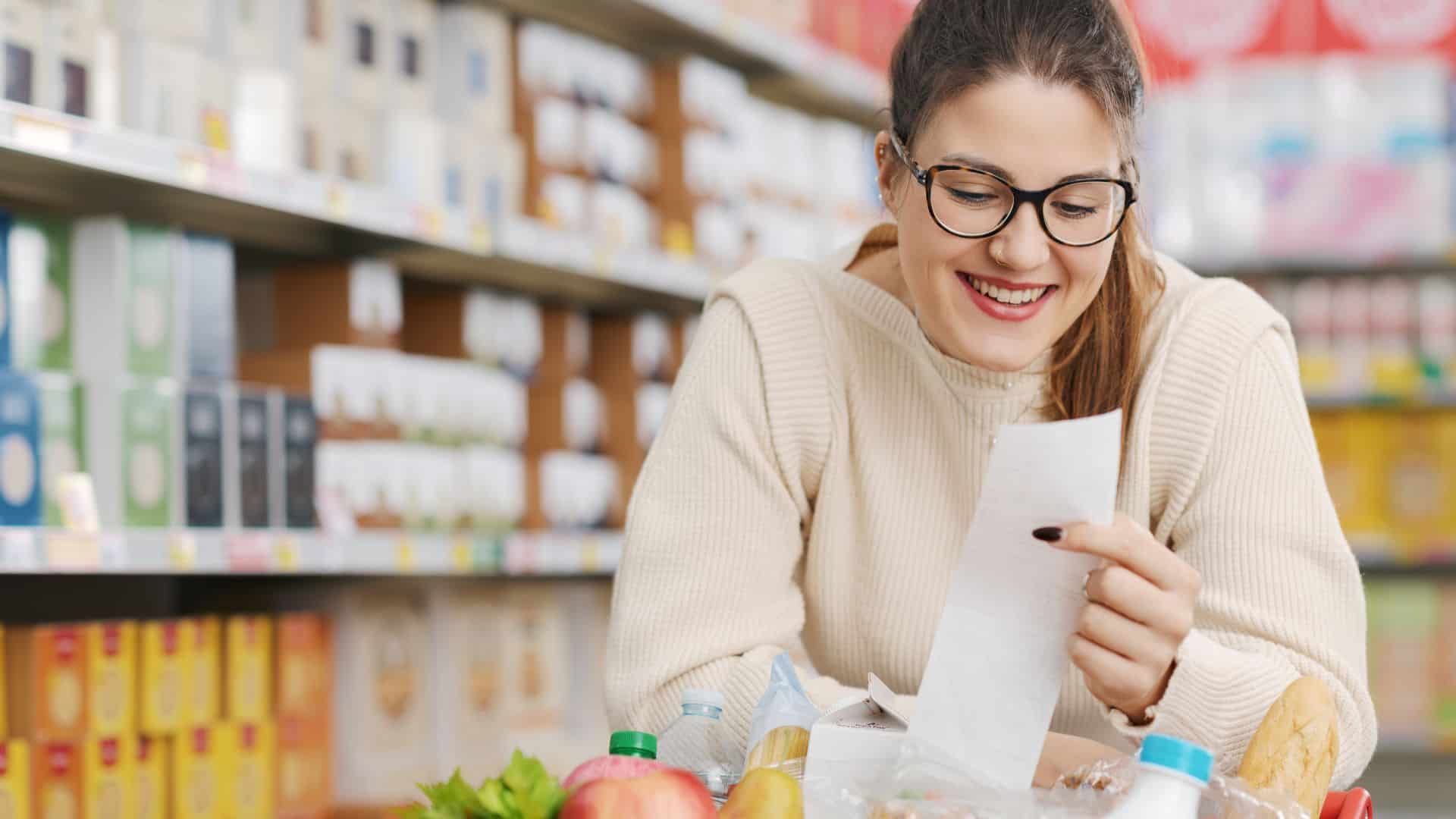 woman holding a long grocery receipt