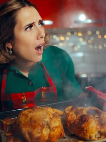 woman holding turkey tray upset with burning smoke