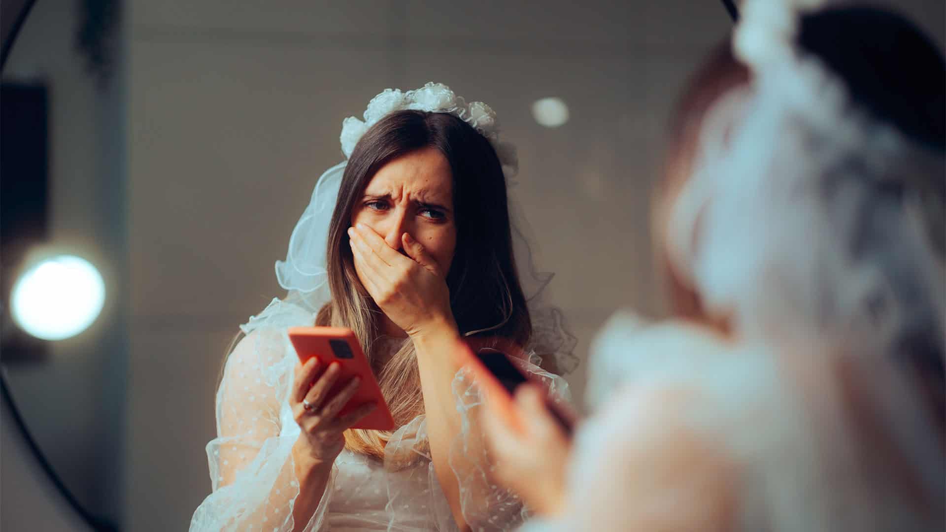 Bride crying in front of a mirror.