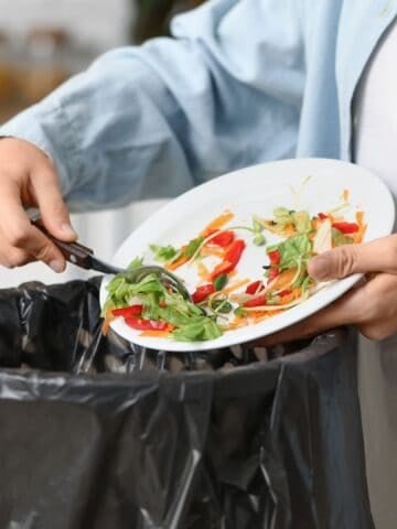 man throwing food in trash