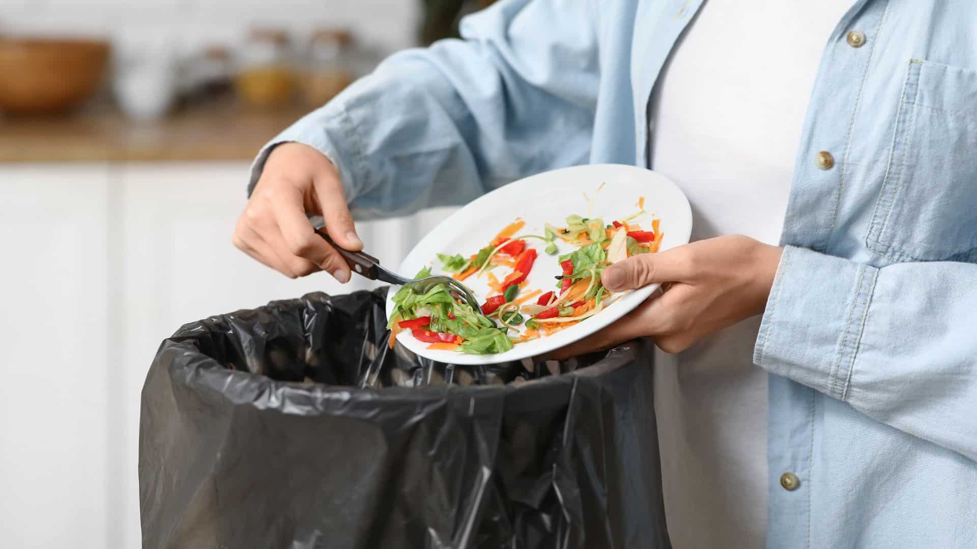 man throwing food in trash