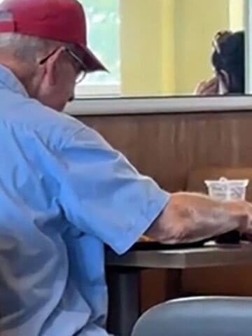 Toddler sitting with an old man at McDonalds
