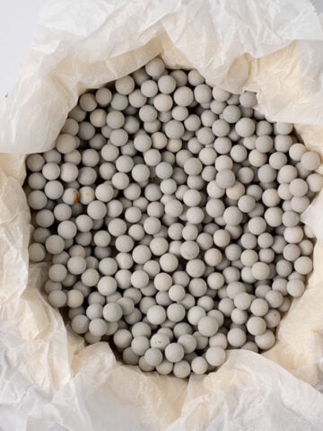 Baking paper and pie weights in a pie crust.